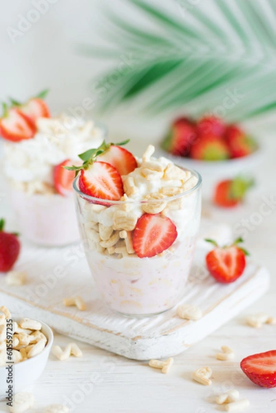 Obraz Desserts of cookies and whipped cream with strawberries in glasses, close-up, background in blur.