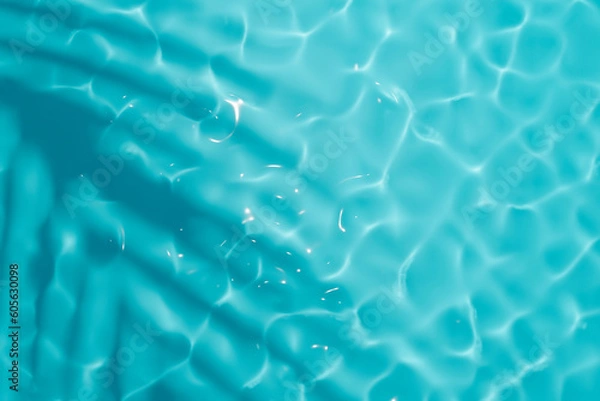 Fototapeta Aqua waves and coconut palm shadow on blue background. Water pool texture top view.Tropical summer mockup design. Luxury travel holiday.