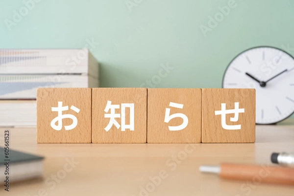 Obraz お知らせと書かれたブロックが置かれたデスク
