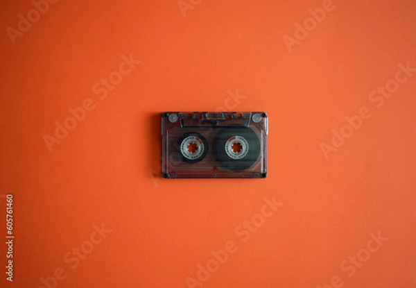Obraz Audio cassette in the middle on an orange background, top view.