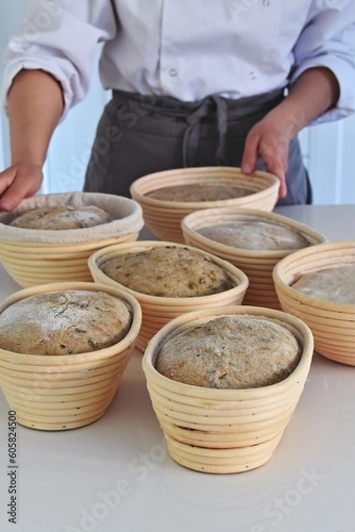 Fototapeta Sourdough bread proofing in the basket. Artisan breadbaking
