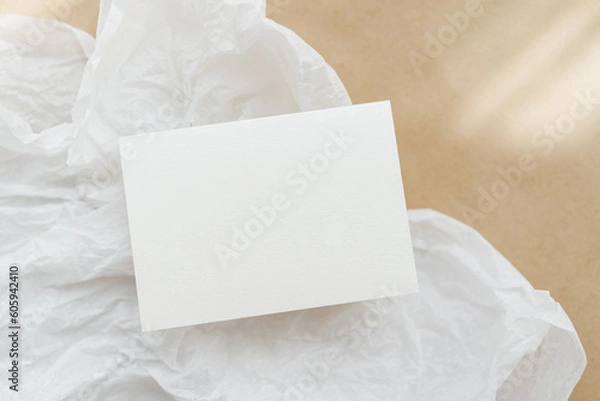 Fototapeta White business card mockup on beige background. Wedding invitation mockup. Name car, place card mock up