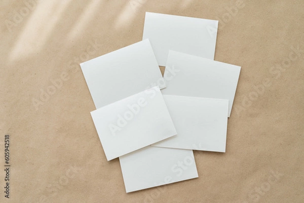 Fototapeta White business card mockup on beige background. Wedding invitation mockup. Name car, place card mock up