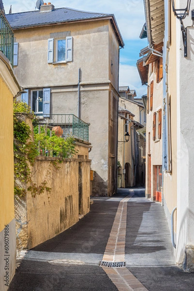 Obraz A scenics view of an alley in Embrun, Hautes-alpes, France old town with colorful typical old house under a majestic blue sky and some white clouds