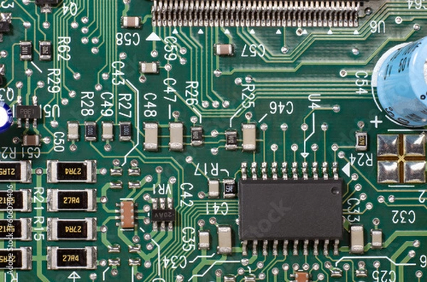 Fototapeta Macro Closeup Green Computer Electronic Circuit board with chips solder traces pads and lettering