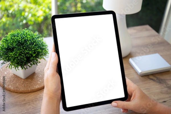 Fototapeta female hands hold computer tablet with isolated screen background table