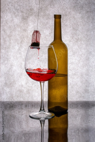 Fototapeta A bottle, a glass with red liquid and a tea bag