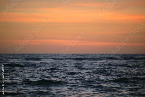 Fototapeta Dramatic red ocean waves at sunset with soft evening sea dark water
