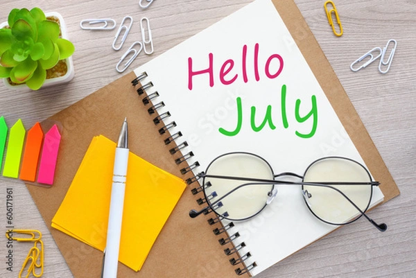 Fototapeta hello july on notepad on wooden background