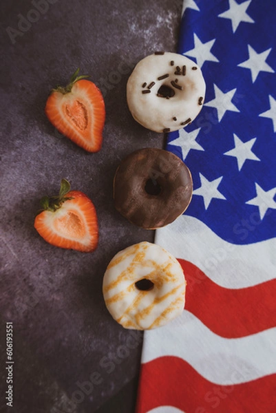 Fototapeta Donuts. Top view. Colorful donuts with icing. On the black background . Colorful glazed doughnuts with sprinkles. Independence Day 4th of July