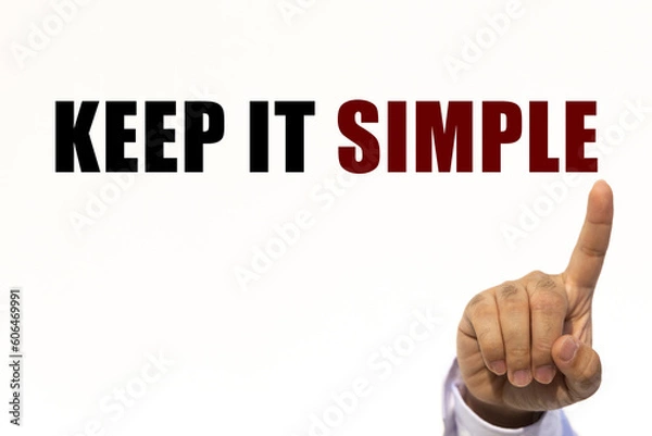 Fototapeta Keep it simple text on white wall background with businessman's finger point at the message with empty space. This message can be used as business concept about keep it simple.