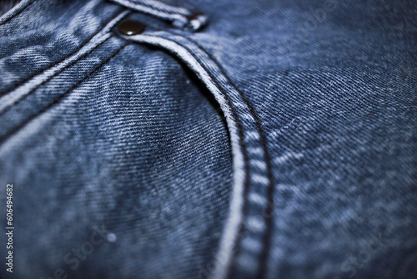 Fototapeta The texture of the blue jeans with the detail of the fabric.