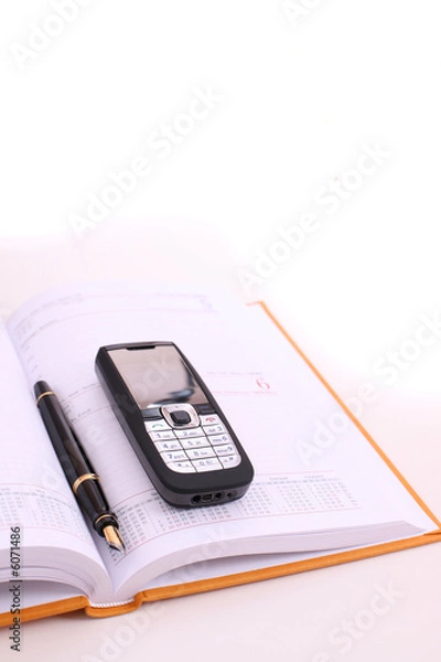 Fototapeta On the desk - cell phone, calendar and pen