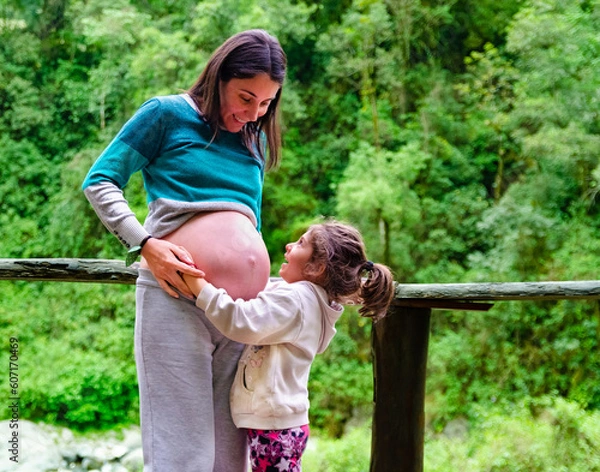 Fototapeta "Looking to the future: Mother and daughter celebrating the arrival of a new member of the family"
