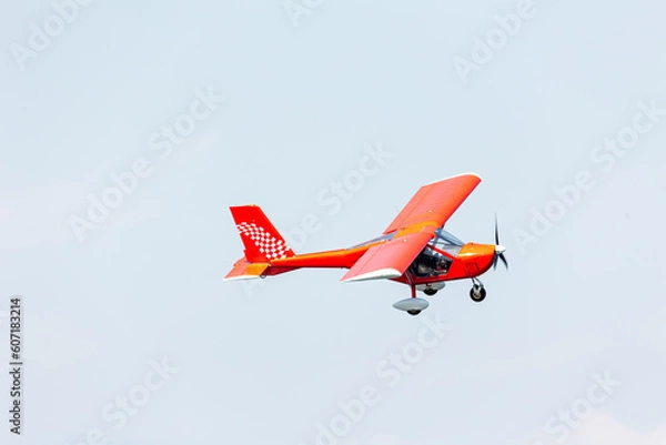 Fototapeta stunt red and white plane glider flying fast over the blue air with motion blur at the propeller at Gijon air show festival