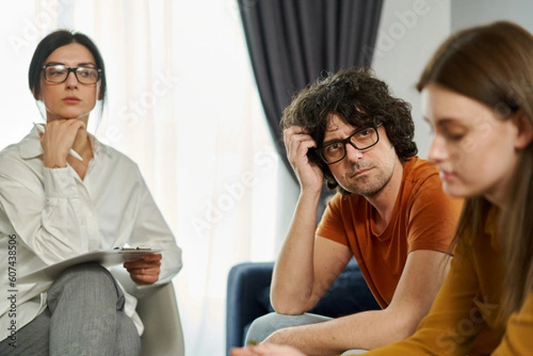Obraz Couple in a therapy session. The man looking at his girlfriend with deep sadness and regret, reflecting the complexities of their relationship.