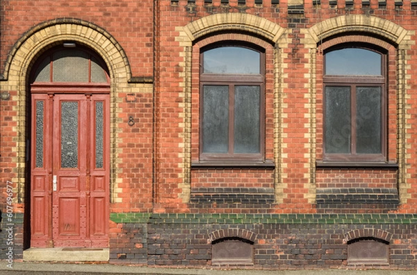 Fototapeta View of brick building with wooden door and windows