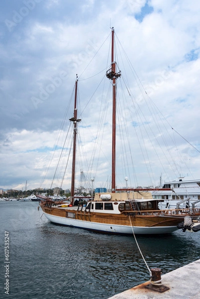 Fototapeta Beautiful wooden yacht moored in marina and bollard in the foreground. Vacation and tourism concept 