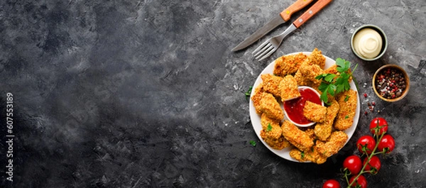 Fototapeta Delicious Crispy Fried Breaded Chicken Breast Strips with Ketchup on Dark Background