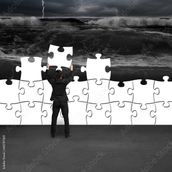 Obraz Businessman holding puzzles to assembly for changing situation