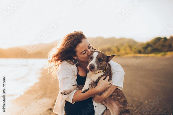 Obraz woman hugging her dog on the beach