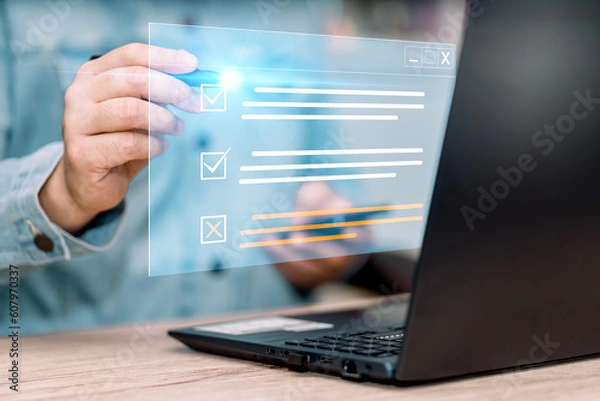 Fototapeta Business performance checklist. Businessman using laptop to do online checklist survey, doing assessment online survey answer test questions Digital form.