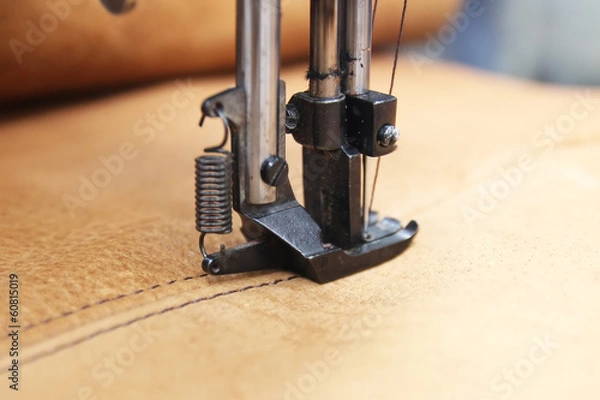 Fototapeta Closeup of sewing machine working part with leather