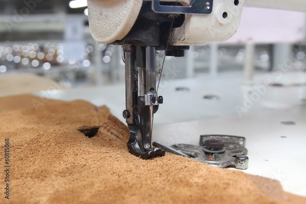 Fototapeta Closeup of sewing machine working part with leather