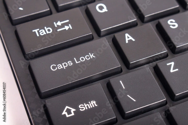 Fototapeta Capslock key on a computer keyboard. Focus on the word capslock it's on the right side.