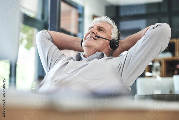 Fototapeta Relax, telemarketing and mature professional at office on a break feeling calm at work. Contact us, call center and businessman with a happy smile with phone consultation and employee communication