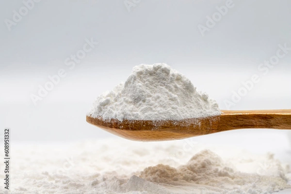 Fototapeta Powdered sugar on wooden spoon. Powdered sugar or icing sugar isolated on white background