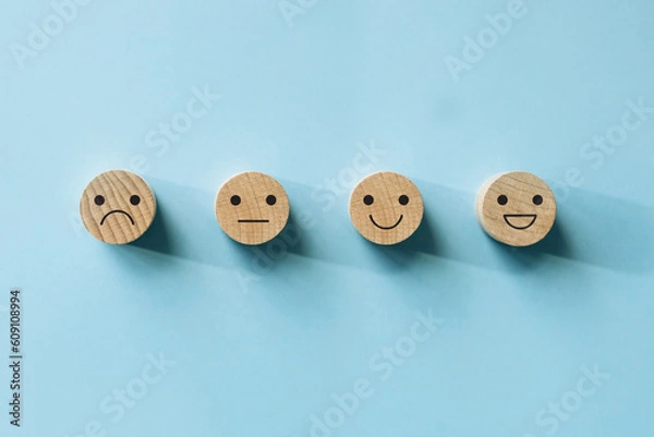 Fototapeta Customer service evaluation and satisfaction survey concepts, evaluation, Increase rating. Happy face smile face icon on wood on blue background