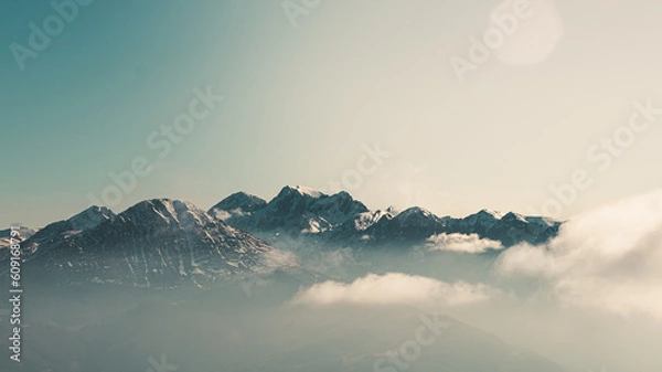Fototapeta Awesome panoramic horizontal photo of sunrise evening of mountains of beautiful Asturias, North of Spain, while clouds and fog cross the hills and are lighted by warm light of the day