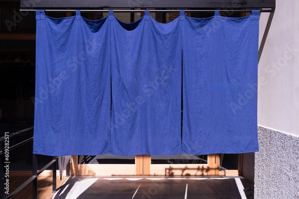 Fototapeta The curtain-like fabric that hangs in front of traditional Japanese restaurants and shops not only serves as a signboard, but holds a larger meaning,