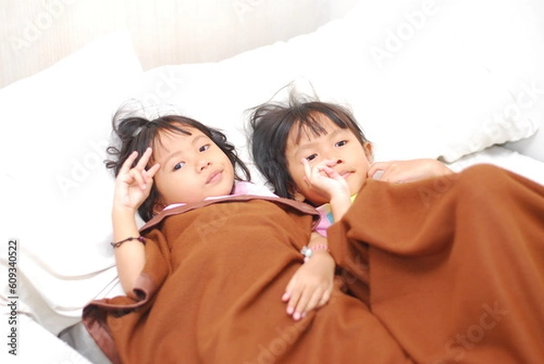 Fototapeta two beautiful Asian girls watching TV in the room while scared