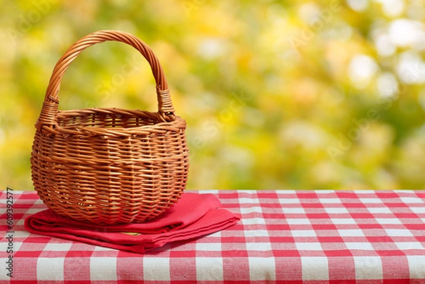 Fototapeta Empty wicker basket on a red checkered tablecloth. Autumn background. Free space for collage
