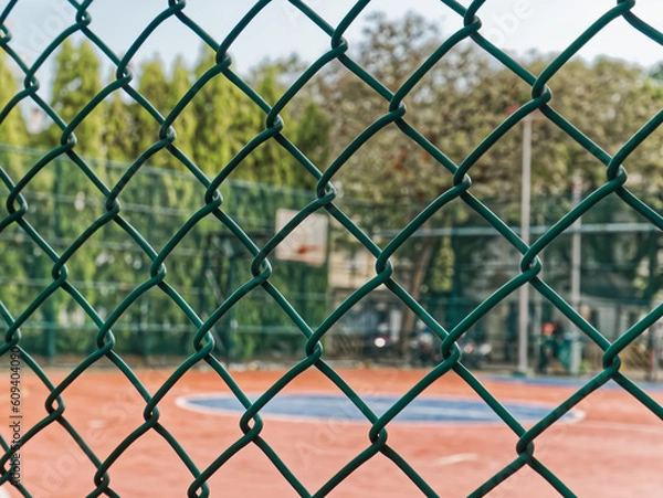Obraz Close-up Green Wire Mesh Metal Fence Around the Basketball Field
