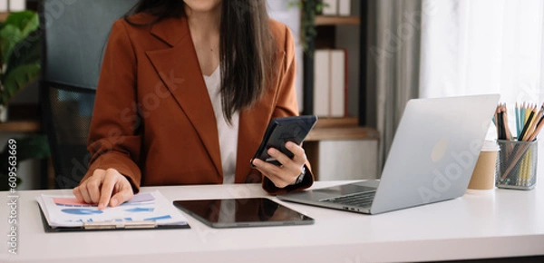 Obraz .Businesswoman hand using laptop, tablet and smartphone. Digital marketing media mobile app and discussing plan new start up project. Finance task.