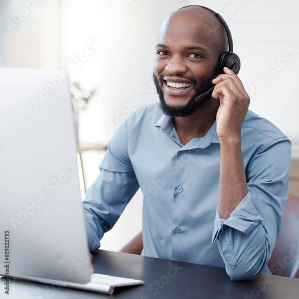 Fototapeta Black man, callcenter with phone call and computer, communication with headset and contact us in office. Male consultant in portrait, customer service and tech support with help desk worker and smile