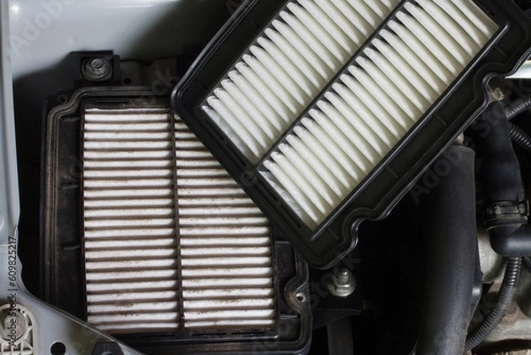 Obraz Replacing the car's air filter. Old and new air filters in the engine compartment of the car.