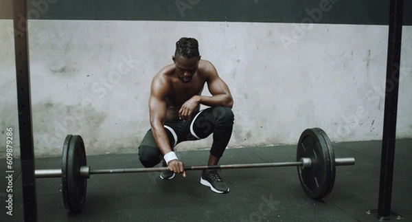 Fototapeta Weightlifting, bodybuilder and black man with barbell in gym for training, exercise and strong workout. Fitness, muscles and male person lifting weights for challenge, wellness and body strength