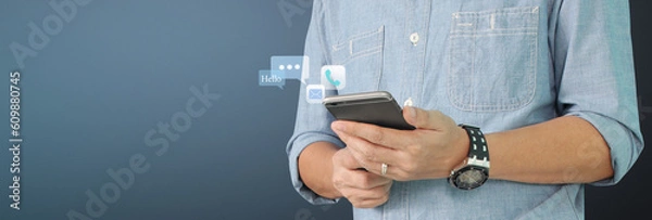 Fototapeta Man holding smartphone device  touching screen