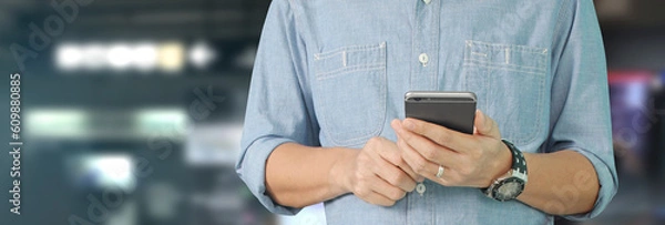Fototapeta Man holding smartphone device  touching screen