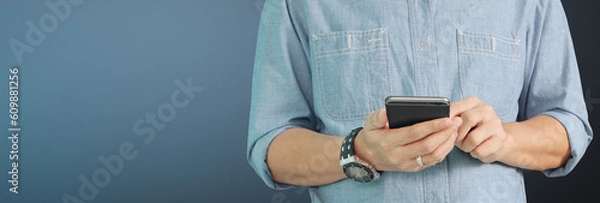 Fototapeta Man holding smartphone device  touching screen