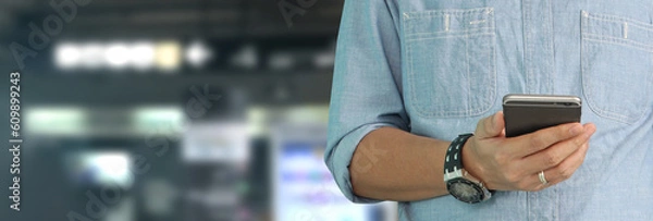 Fototapeta Man holding smartphone device  touching screen