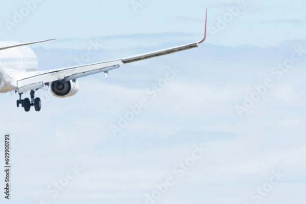 Fototapeta Wing of plane as it flies through the sky