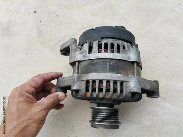 Fototapeta Hand holding a car battery charger