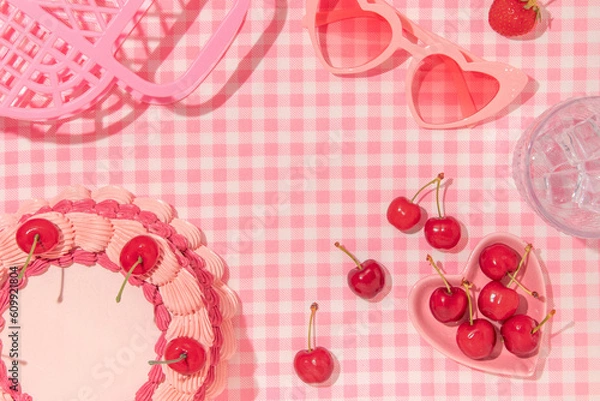 Fototapeta Summer creative layout with vintage cake, cherries, glass with ice cubes, heart sunglasses and handbag on pastel pink plaid background. 80s or 90s retro aesthetic idea. Minimal summer fruit idea.