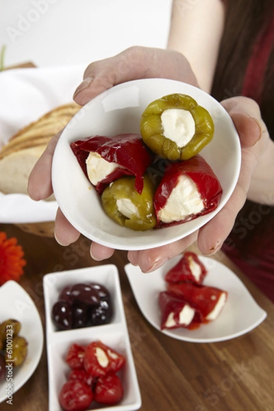 Fototapeta Junge Frau mit Antipasti - gefüllte Paprikaspitzen