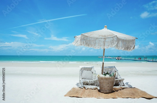 Fototapeta Beautiful bech. chairs and umbrella on the beach, blue sky. blue sky and ocean. vacation and resort concepts. Relax in style on a beautiful white sand beach with beach chairs and an umbrella.